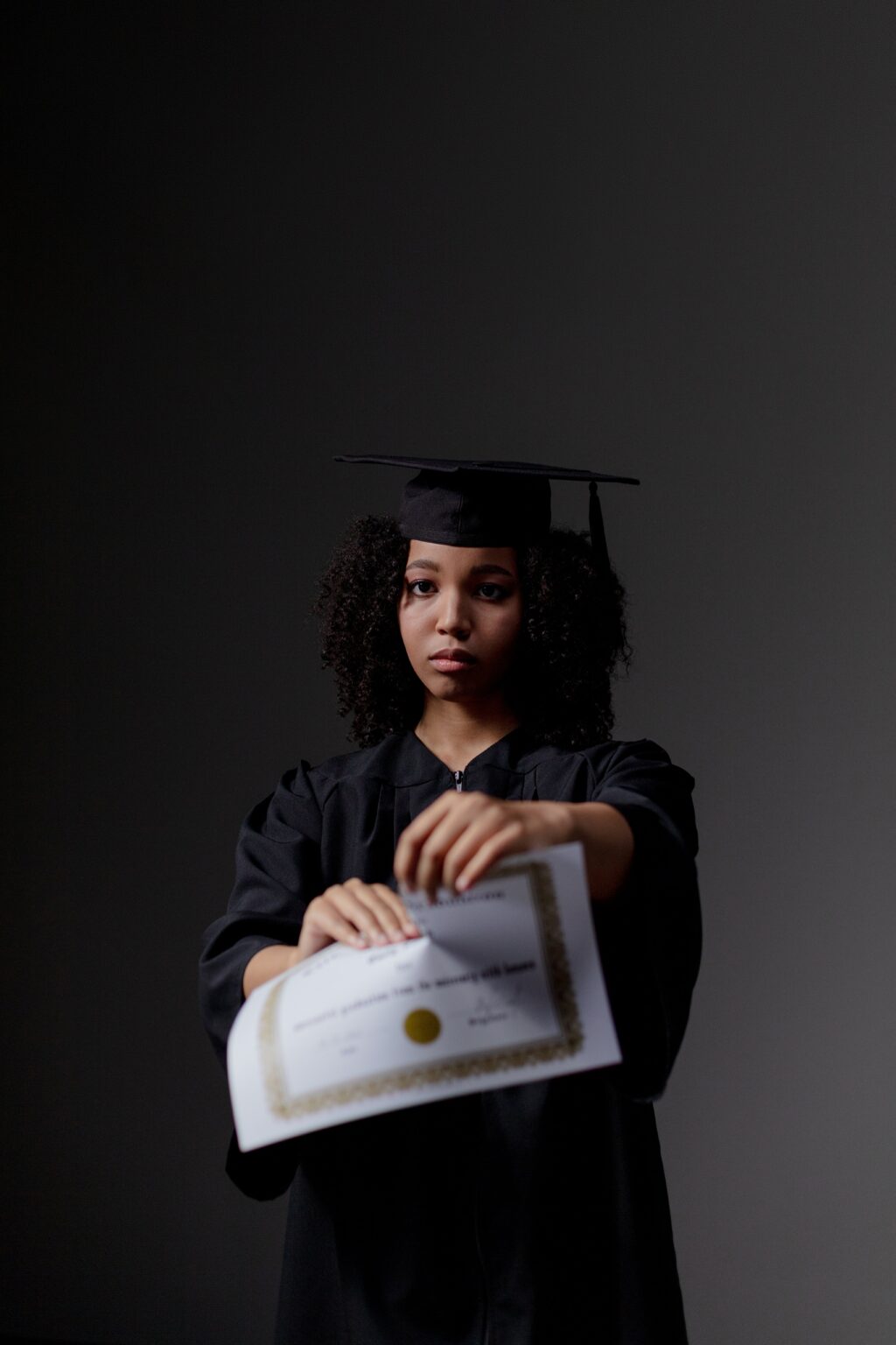 Photo by Ron Lach : https://www.pexels.com/photo/woman-in-black-academic-dress-tearing-her-diploma-9829315/